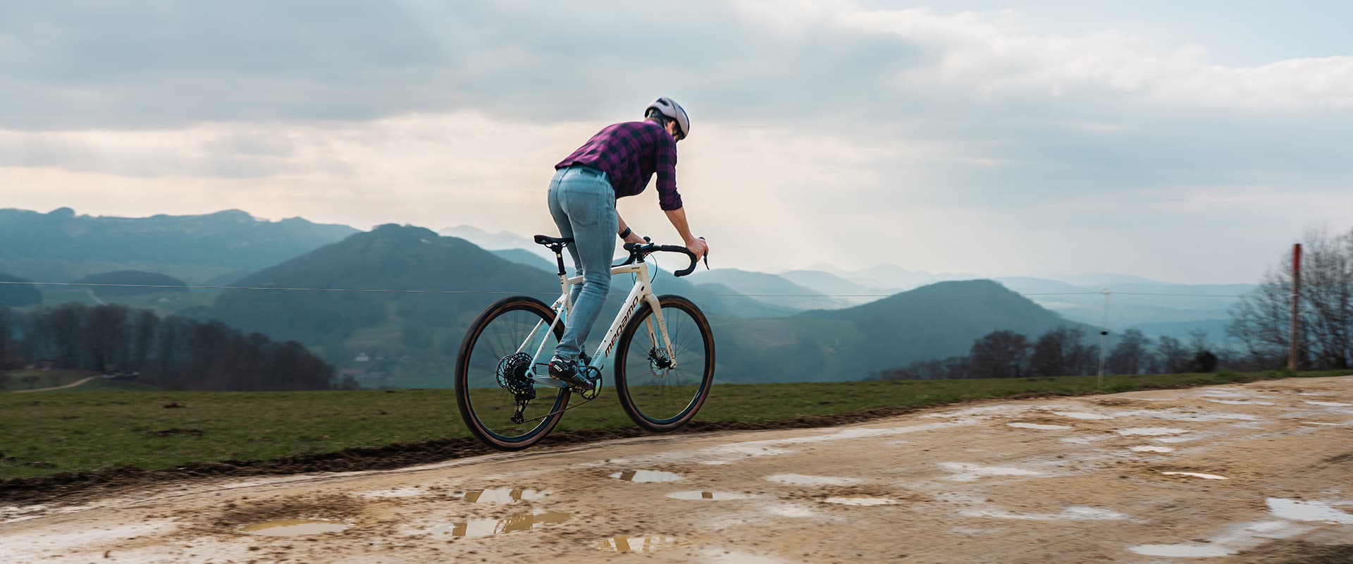 Radfahrerin auf einem Gravelbike vor einer Berglandschaft